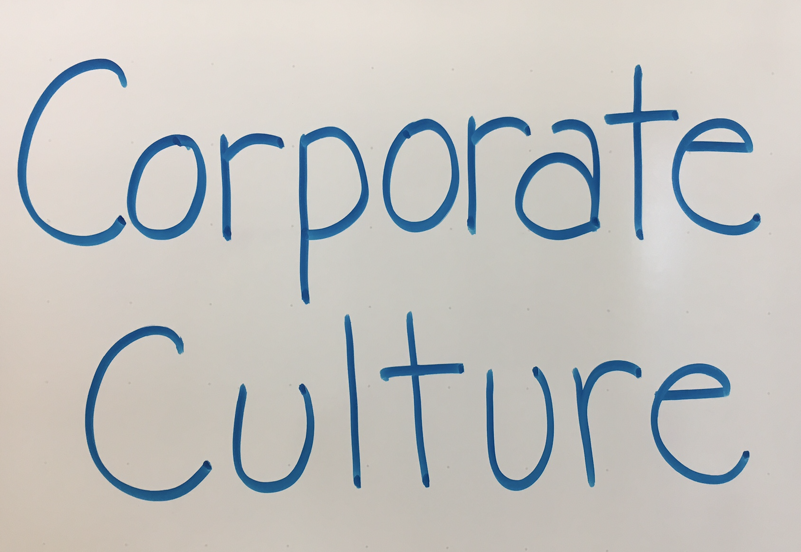 Handwritten words: "Corporate Culture" written on a white board